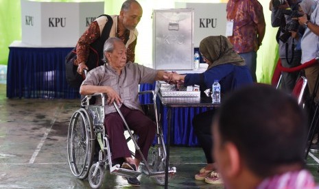 Seorang disabilitas mengikuti proses pencoblosan Pilkada DKI Jakarta di TPS 6, Rawa Barat, Jakarta, Rabu (15/2). 