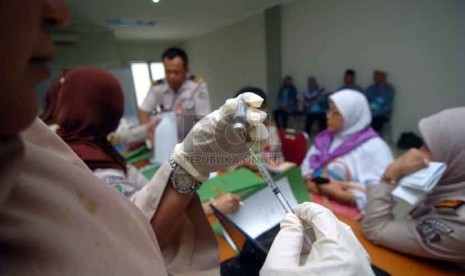 Seorang dokter memasukan vaksin meningitis di puskesmas Pondok Asrama haji, Pondok Gede, Jakarta Timur, Ahad (31/8).(Republika/Raisan Al Farisi)