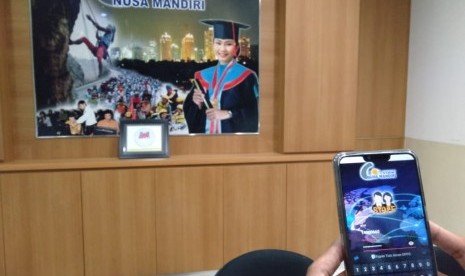 Seorang dosen STMIK Nusa Mandiri tengah menggunakan aplikasi My Staff Nusamandiri.