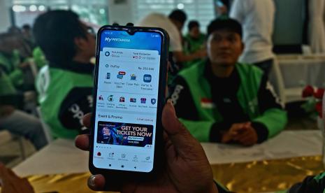  Seorang driver ojek online (ojol) menunjukkan aplikasi MyPertamina di smartphone miliknya, saat mengikuti launching program ‘MyPertamina Hero Riders’, di Semarang.