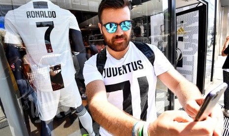 Seorang fan Juventus berfoto dengan kostum Cristiano Ronaldo di toko resmi Juventus di Milan.