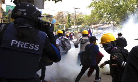 Seorang fotografer dengan rompi pelindung merekam aksi protes antimiliter yang dibubarkan dengan gas air mata di Yangon, Myanmar, 3 Maret 2021. Junta militer Myanmar akan menghukum mati empat orang warga yang dinilai anti terhadap Dewan Administrasi Negara.