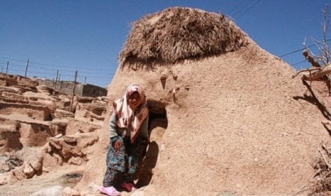 Seorang gadis berpose di depan rumah penduduk Makhunik di Iran.