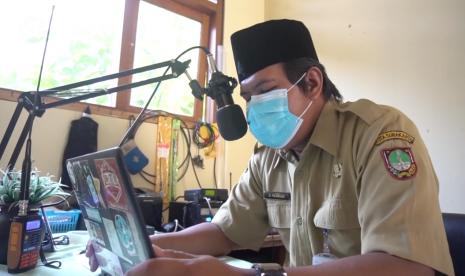 Seorang guru di Solo, Jawa Tengah menggunakan portofon untuk melakukan kegiatan belajar dan mengajar di tengah pandemi Covid-19.