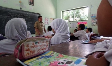 Seorang guru honorer melakukan proses belajar mengajar di Madrasah Ibtidaiyah Bandung III Jombang, Jawa Timur, Selasa (24/11).