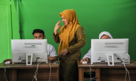 Seorang guru memberikan arahan kepada siswa disabilitas sebelum menjalani ujian asesmen nasional berbasis komputer (ANBK) di SLBN Cicendo, Bandung, Jawa Barat. (ilustrasi)