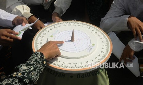 Seorang guru memperkenalkan jam Istiwak atau jam matahari kepada santri di Masjid Menara Kudus, Jawa Tengah, Sabtu (26/5). 