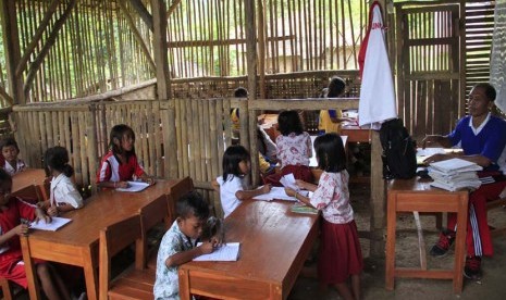   Seorang guru mengajar dua kelas sekaligus di ruangan terbuat dari bambu di SD Negeri Girijagabaya, di Kampung Sinarjaya, Muncang, Lebak, Banten, Rabu (27/11). (Antara/Asep Fathulrahman)