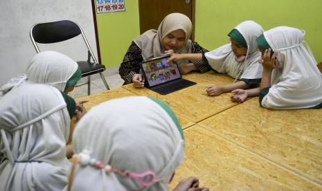 Seorang guru mengajar murid pendidikan anak usia dini (PAUD) menggunakan gim edukasi di Paud Sanggar Cerdas Elina, Tangerang Selatan, Banten, Senin (31/10/2022). Kementerian Pendidikan, Riset dan Teknologi (Kemendikbudristek) mendorong pendidikan berbasis teknologi pada jenjang PAUD hingga perguruan tinggi sebagai upaya pemulihan pendidikan usai pandemi.