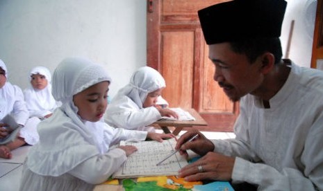 Seorang guru mengajari anak membaca dan menghafal Al-Quran