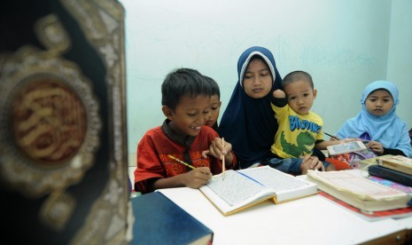 Berbagi Berkah Ramadhan pada Ustadz dan Guru Mengaji. Seorang guru mengajarkan anak muridnya mengaji.