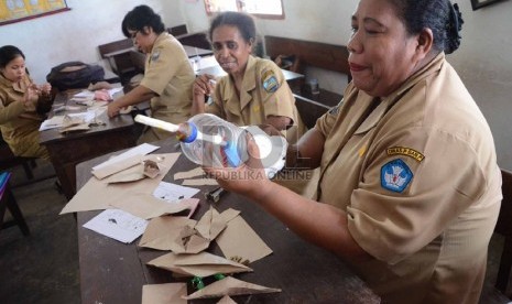    Seorang guru mengamati alat peraga di SD YPK 14 Maranatha, Manokwari, Papua Barat, Rabu (20/11).  (Republika/Edi Yusuf)