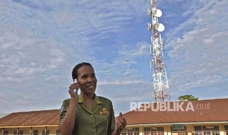 Seorang guru menggunakan layanan jaringan Telkomsel, di Tobelo, Halmahera Utara, belum lama ini.