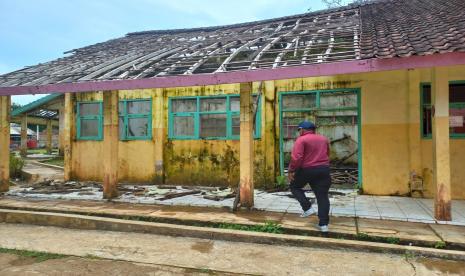 Seorang guru menunjukan kondisi ruang kelas di SDN Banjarwangi, Kampung Banjaran, Desa Banjarwaringin, Kecamatan Salopa, Kabupaten Tasikmalaya, Selasa (11/10/2022). Puluhan siswa di sekolah itu harus belajar di tenda darurat lantaran kondisi kelas rusak. 