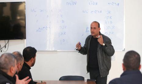 Seorang guru Palestina mengajar bahasa Ibrani ke sekelompok siswa di Nafha Language Center, Khan Younis, selatan Jalur Gaza, 16 Februari 2022.