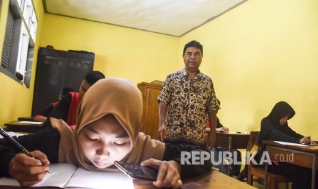 Seorang guru pegawai negeri sipil (PNS) mengajar di Sekolah 