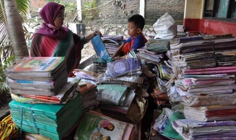 Seorang Guru SDN 07 Petamburan menyortir buku-buku yang basah akibat banjir yang merendam kawasan Petamburan Jakarta Barat,Senin (21/1).(Republika/Rakhmawaty La'lang)