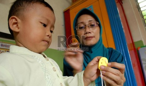  Seorang guru tengah membimbing muridnya di BKB Pendidikan Anak Usia Dini (PAUD) Mawar, Manggarai, Jakarta Selatan, Jakarta Pusat, Kamis (30/8).  ( Republika/Rakhmawaty La'lang)