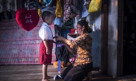 Seorang ibu di daerah terpencil di Kepulauan Karimata, Kalbar memakaikan seragam, Senin (19/10)