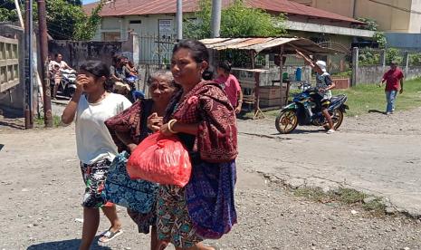 Seorang ibu dipapah anaknya saat mengungsi ke tempat yang lebih aman menyusul adanya peringatan dini tsunami di Kota Maumere, Kabupaten Sikka, NTT, Selasa (14/12/2021). Gempa berkekuatan 7,4 skala richter pada pukul 11.20 Wita di Laut Flores tersebut disusul adanya peringatan dini tsunami dari BMKG sehingga mengakibatkan warga di Kota Maumere berhamburan mengungsi karena trauma dengan tsunami yang pernah terjadi pada tahun 1992.