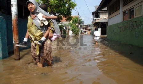  Seorang ibu melintasi banjir yang menggenangi kawasan Kampung Melayu Kecil 1, Poncol, Bukit Duri, Jakarta Selatan,Senin (22/10).   (Agung Fatma Putra)