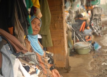 Seorang ibu pedagang barang-barang bekas sedang menanti pembeli di Pasar Loak, samping rel kereta api di Pasar Lama, Jalan Dewi Sartika, Depok, Jawa Barat, Selasa (17/1). (Republika/Rusdy Nurdiansyah)