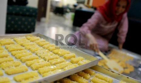 Seorang ibu rumah tangga menyelesaikan pesanan kue kering di Jakarta, Selasa (1/7).