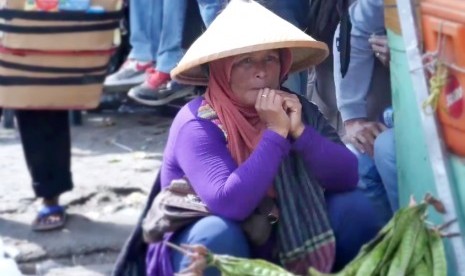 Seorang ibu sedang menjual sayur di kawasan Pasar Minggu