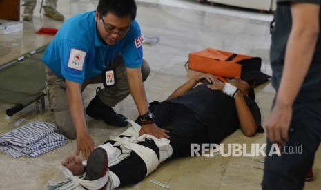 Seorang instruktur memberikan pertolongan terhadap korban ketika pelatihan penanganan korban yang diselenggarakan PMI dan Pewarta Foto Indonesia (PFI), di gedung PMI Pusat, Jakarta, Ahad (3/12). 