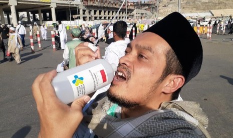 Seorang jamaah haji Indonesia asal Surabaya sedang meminum air dari botol di Terminal Syib Amir, Makkah, Jumat (26/7). Dengan suhu udara yang panas di Makkah, mengharuskan jamaah haji untuk sering minum agar tidak dehidrasi. 