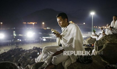 Seorang jamaah haji membaca al quran di Jabal Rahmah, Padang Arafah, Kamis (31/8)