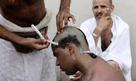   Seorang jamaah haji mencukur rambutnya usai melontar jumrah Aqabah di Mina, dekat kota suci Makkah, Jumat (26/10).    (Hassan Ammar/AP)