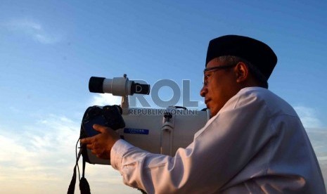 Seorang jamaah Masjid Jami Al-Musari'in Basmol mengamati posisi hilal di Kembangan Utara, Jakarta Barat, Senin (8/7).  (Republika/Agung Supriyanto)