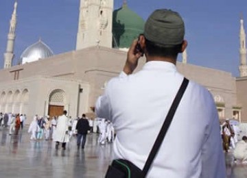 Seorang jamaah menepon dari halaman Masjid Nabawi, Makkah