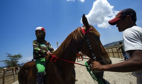   Seorang joki cilik siap turun ke arena pacu kuda di kawasan Penyaring, Moyo Utara, Sumbawa, NTB, Ahad (11/11).   (Antara/Ismar Patrizki)