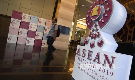 Seorang jurnalis melintasi ornamen penyambutan delegasi jelang rangkaian Konferensi Tingkat Tinggi (KTT) ASEAN ke-34 di Bangkok, Thailand, Kamis (20/6). KTT ASEAN ke-34 yang dilaksanakan 20-23 Juni 2019 tersebut mengangkat tema Memajukan Kemitraan Untuk Keberlanjutan. 