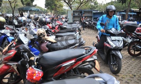 Seorang juru parkir mengarahkan pengendara saat parkir di kawasan IRTI MOnas, Jakarta Pusat, Selasa (26/5).