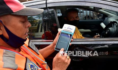 Seorang juru parkir menghitung tarif parkir dengan alat digital (ilustrasi).