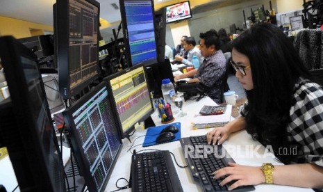  Seorang karyawati memantau pergerakan Indek Harga Saham Gabungan (IHSG) di Mandiri Securitas, Jakarta, Selasa (20/12).