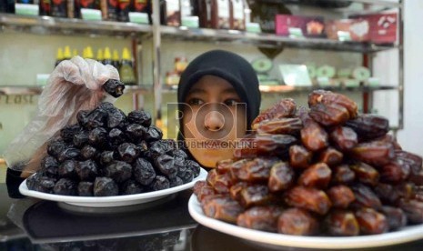  Seorang karyawati menata kurma yang dipajang di salah satu butik kurma di PGC Cililitan, Jakarta, Senin (29/7). (Republika/Agung Supriyanto)