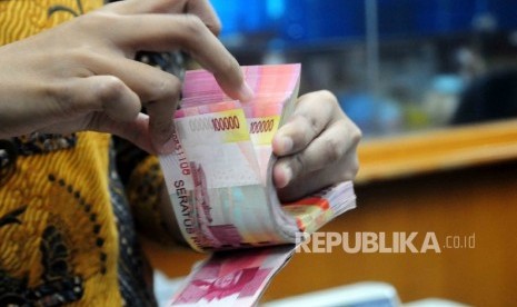 Seorang karyawati menghitung uang Rupiah pecahan seratus ribu disalah satu tempat penukaran uang di Jakarta Pusat, Senin (18/7).  (Republika/Agung Supriyanto)