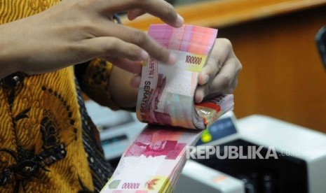 Seorang karyawati menghitung uang Rupiah pecahan seratus ribu disalah satu tempat penukaran uang di Jakarta Pusat, Senin (18/7).  (Republika/Agung Supriyanto)