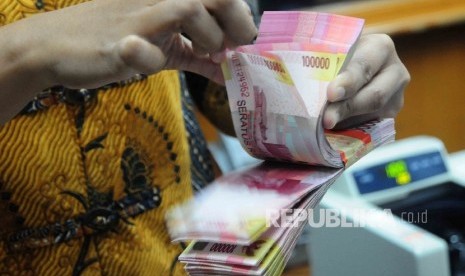 Seorang karyawati menghitung uang Rupiah pecahan seratus ribu disalah satu tempat penukaran uang di Jakarta Pusat, Senin (18/7).  (Republika/Agung Supriyanto)