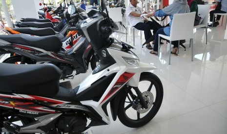 Seorang konsumen melihat-lihat produk motor honda di salah satu Showroom Motor Honda