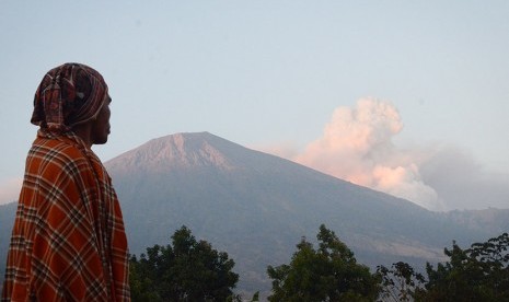 Seorang laki-laki memperhatikan semburan material vulkanik Gunung Barujari dari Desa Sembalun Lawang, Kecamatan Sembalun, Selong, Lombok Timur, NTB, Selasa (10/11).