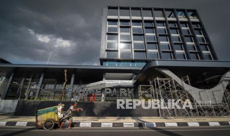 Seorang laki-laki menarik gerobak sampah melintas dekat proyek pembangunan hotel berbintang yang hampir selesai dikerjakan di Mataram, NTB, Senin (4/10/2021). Dinas Pariwisata Kota Mataram, Provinsi Nusa Tenggara Barat, menargetkan tingkat hunian hotel bisa mencapai 100 persen saat kegiatan ajang balap motor dunia atau World Superbike (WSBK) di Sirkuit Mandalika Lombok pada November 2022.