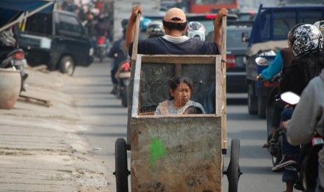 Seorang lelaki dari keluarga miskin mengangkut anak dan istrinya dengan gerobak. ilustrasi (Dok Republika)