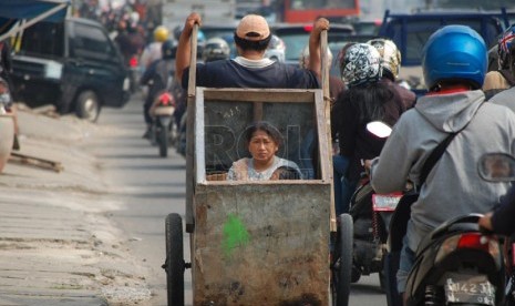 Seorang lelaki dari keluarga miskin mengangkut anak dan istrinya dengan gerobak di jalanan di Jakarta. ilustrasi (foto: Raisan Al Farisi)