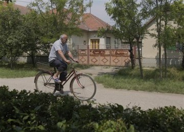 Seorang lelaki tua, dengan sepeda ontel, melintasi depan rumah tempat persembunyian Ratko Mladic si Jagal Balkan, di desa Lazarevo, Beograd, Serbia, Sabtu (28/5).