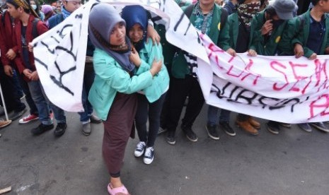 Seorang mahasiswa mengevakuasi temannya yang sakit saat berlangsungnya aksi demonstrasi memperingati Hari Kebangkitan Nasional (Harkitnas) di depan Istana Merdeka, Jakarta, Kamis (21/5). Aksi yang diikuti ribuan mahasiswa berbagai daerah itu sekaligus meny